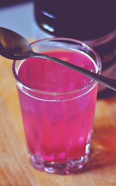 a spoon sitting on top of a glass filled with liquid