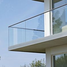 a cat sitting on top of a window sill in front of a white building