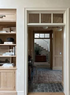 an open door leading to a living room with bookshelves and other items on the shelves