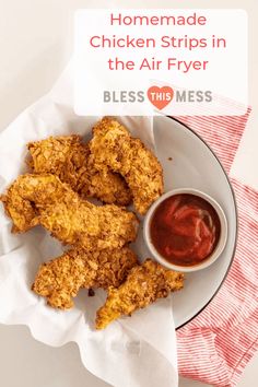 fried chicken strips in the air fryer on a white plate with ketchup