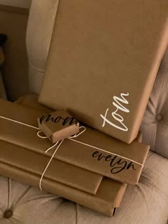 two wrapped presents sitting on top of each other in front of a couch with the word love written on it