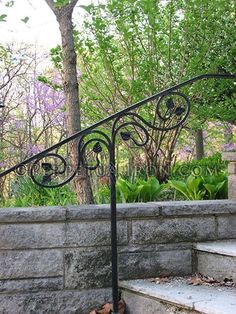 an iron hand rail on top of some steps