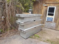 three metal boxes are stacked on top of each other in front of an old building