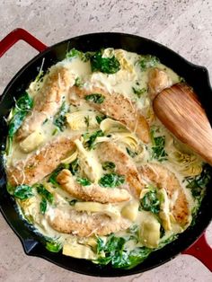 a skillet filled with chicken, spinach and cheese