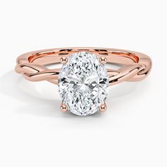 a rose gold ring with an oval cut diamond in the center and twisted band around it