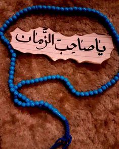 a blue beaded necklace with arabic writing on it