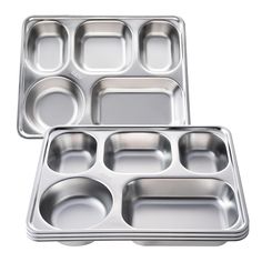 two metal trays filled with food on top of a white background, one is empty and the other has four compartments