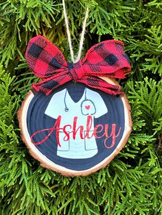 a personalized christmas ornament hanging on a tree branch with a red bow