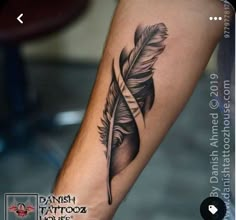 a black and white photo of a feather tattoo on the arm with an arrow in it