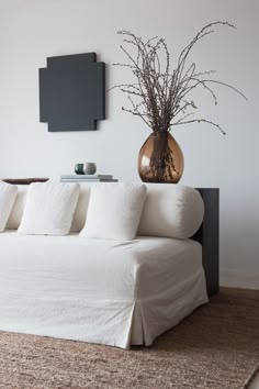 a living room with a white couch and brown vase