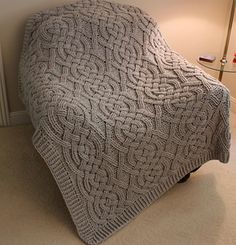 a bed with a blanket on top of it next to a radiator and lamp