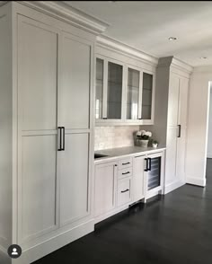 an empty kitchen with white cabinets and black flooring is pictured in this image from the front view