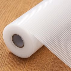 a roll of white plastic sitting on top of a wooden table