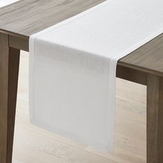 a white table runner on top of a wooden table