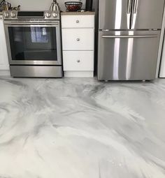 a kitchen with marble floors and stainless steel appliances