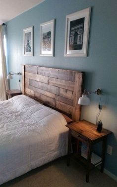 a bed sitting in a bedroom next to two framed pictures on the wall above it