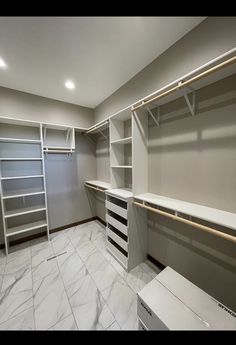 an empty walk in closet with shelves and drawers