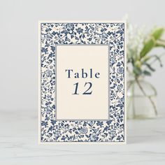 a table number card with blue and white flowers