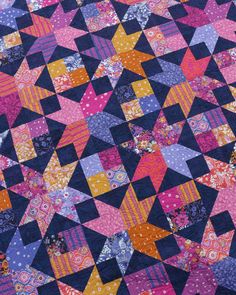 a colorful quilt with many different patterns on it