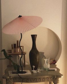 a lamp that is on top of a table next to a vase and other items