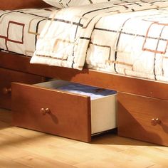 a bed with two drawers underneath it on the floor next to a night stand and nightstand