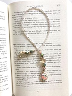 an open book with a necklace on it