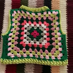 a crocheted square is sitting on top of a blanket