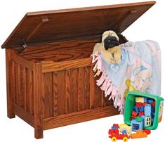 a wooden toy chest with a pug dog in it's blanket and toys