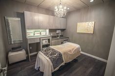 a bedroom with a bed, dresser and mirror in it's center area that has a chandelier hanging from the ceiling