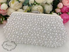 This elegant bridal clutch features silver trim, attachable chain and large enough for your phone. Complete your list of must-have wedding accessories with the ultimate bridal accessory to finish off your look and storing your wedding day essentials. Details： Inside Material: Satin Size: 9.6*2*5.5inch/24.5*5*14cm Come with a removable short chain（37cm） and a long chain（116cm) and a pearl chain that can be used as shoulder bag or crossbody bag or as clutch. Request a cancellation within 24 hours Silver Evening Bag With Pearl Handle For Wedding, Elegant Evening Bag With Pearl Embroidery For Wedding, Formal Bridal Accessories In Pearl White, Elegant White Bridal Accessories For Evening, White Pearl Evening Bag For Party, Rectangular Pearl White Evening Bag For Wedding, Glamorous White Evening Bag For Wedding, White Clutch Evening Bag For Wedding Guest, Pearl White Rectangular Evening Bag For Wedding