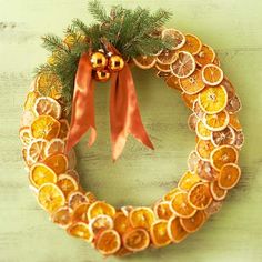 a wreath made out of oranges and lemon slices with a gold bow on it