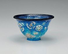 a blue glass bowl with flowers painted on it