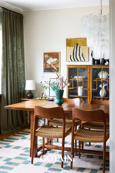 a dining room table with chairs and vases on it