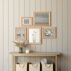 there are many pictures on the wall above the table with baskets and flowers in them