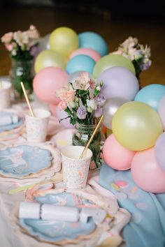 a table topped with plates and vases filled with flowers