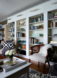 a living room filled with lots of furniture and bookshelves