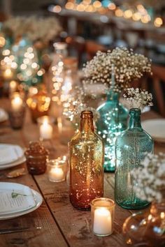 the table is set with candles and vases filled with baby's breath flowers