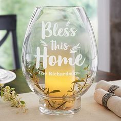 a glass vase sitting on top of a table next to a napkin and flower arrangement