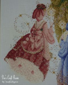 a cross stitch picture of two women in dresses