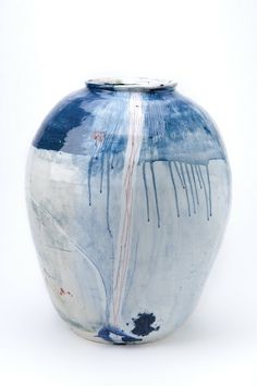 a blue and white vase sitting on top of a table next to a white wall