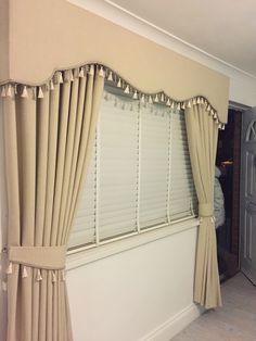 a living room with white walls and beige curtains