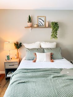 a bedroom with a bed, nightstands and plants on the headboard above it