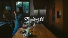 a woman standing in a kitchen next to a counter with food on it and the words madewell above her