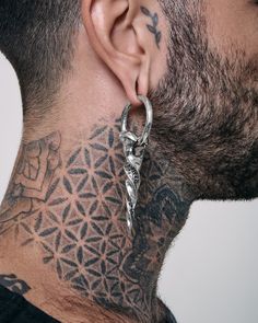 a man with tattoos on his neck and behind the ear is a pair of scissors