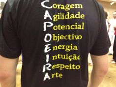 the back of a man wearing a black shirt with latin writing on it's chest