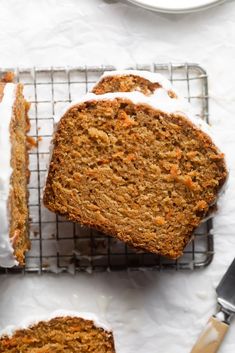 sliced carrot cake on a cooling rack with one slice cut out and another half eaten