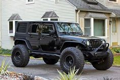 a black jeep parked in front of a house