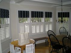 a dining room table and chairs with white blinds