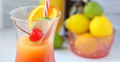 three glasses filled with fruit sitting on top of a table next to two strawberries