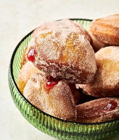 powdered sugar covered pastries in a green bowl